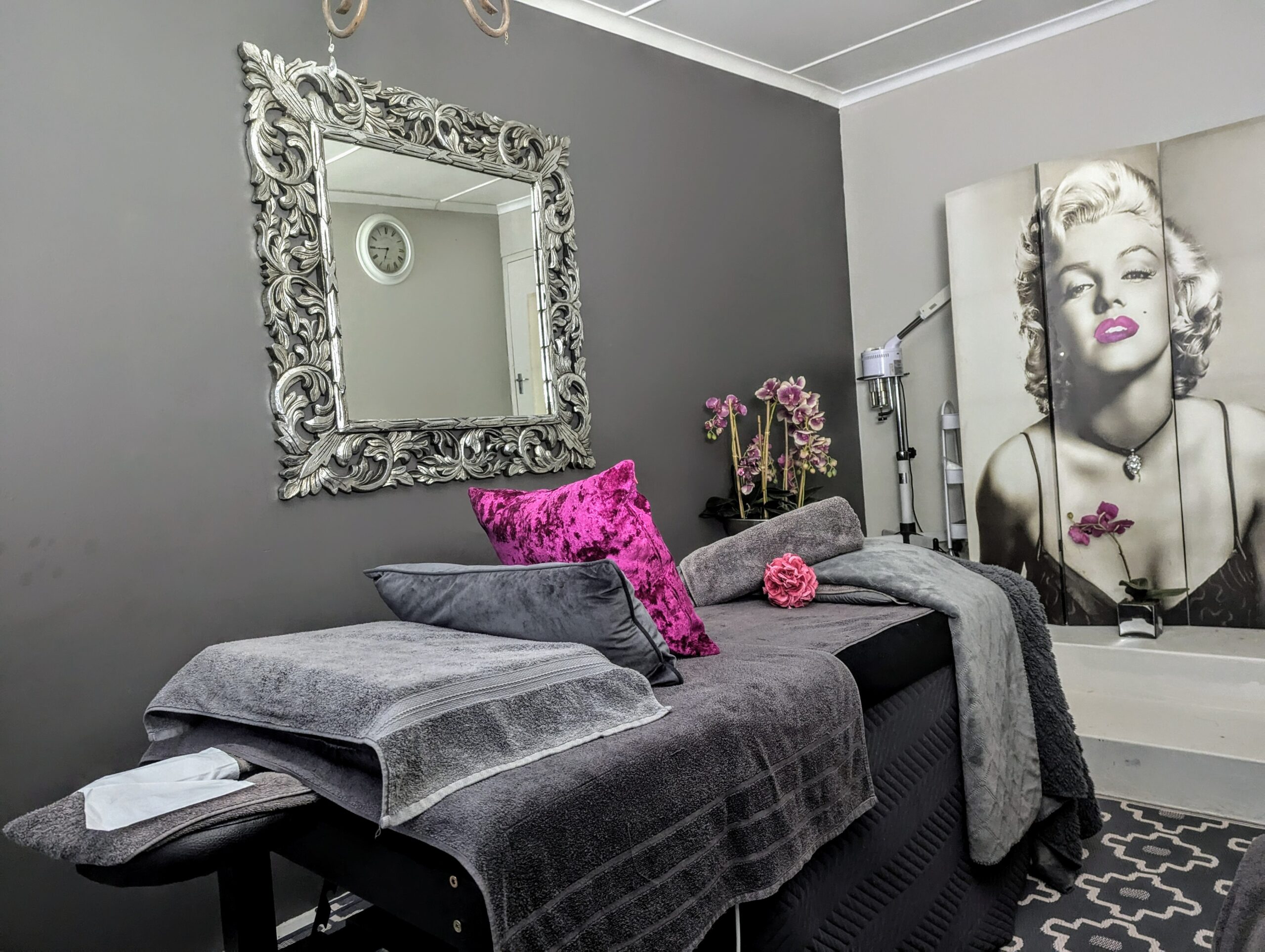 chi chis retreat and spa massage bed in grey setting with mirror and painting